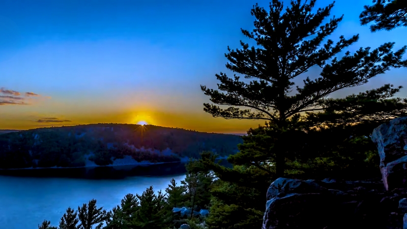 A Sunset View Over a Wisconsin Landscape with Trees and A Calm Lake, Capturing the Beauty of The Outdoors